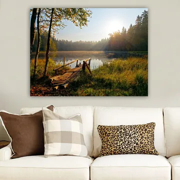 Lerretsbilde 70x100 cm - Rolig innsjø med en trebro omgitt av frodige trær og morgensolens stråler - Grønn / Brun / Gul - Interiør - Maleri & posters - Lerretsbilder