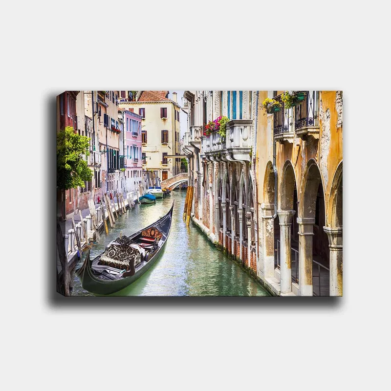 Lerretsbilde 70x100 cm - Romantisk kanal i Venezia med en gondol som glir mellom fargerike bygninger, Grønn / Beige / Blå