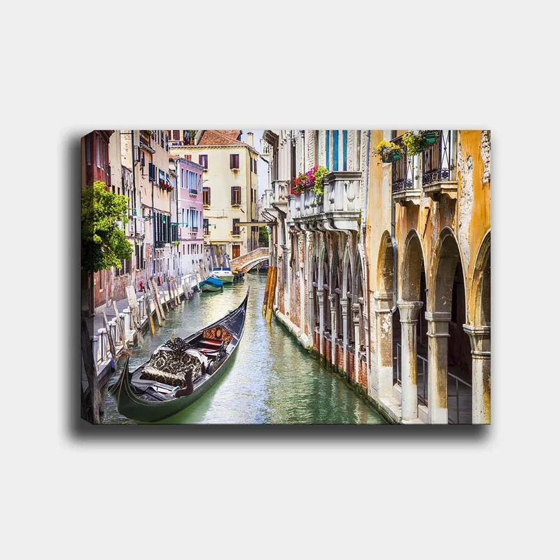 Lerretsbilde 70x100 cm - Romantisk kanal i Venezia med en gondol som glir mellom fargerike bygninger, Grønn / Beige / Blå