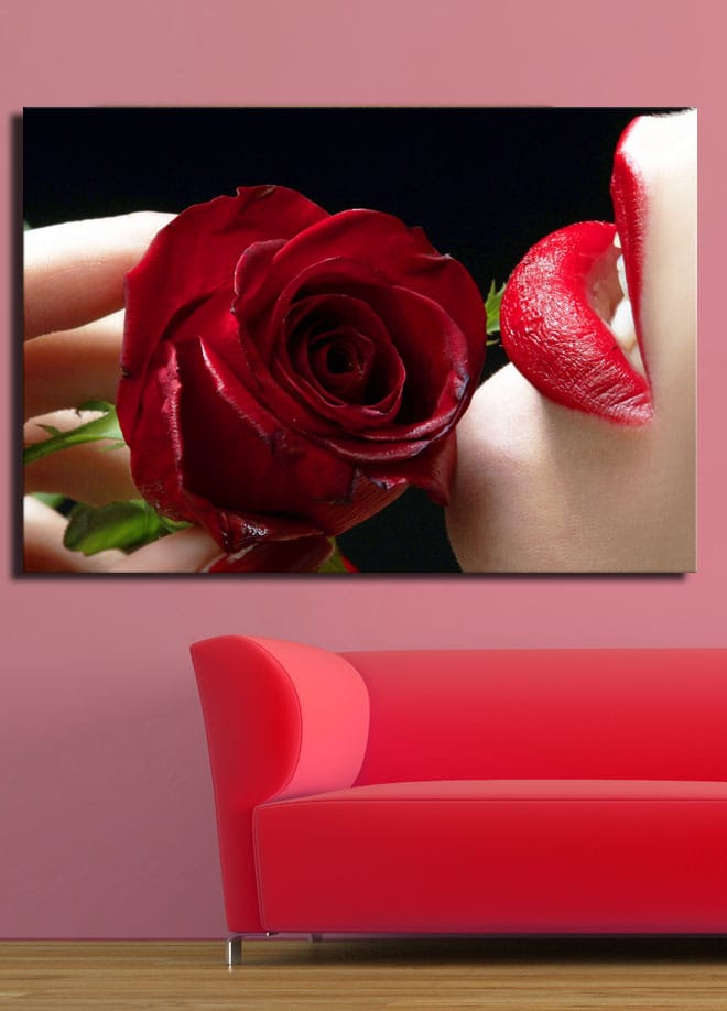 Lerretsbilde 70x100 cm - Sensuell nærbilde av en rose holdt tett inntil en leppe med rød leppestift - Rød / Grønn - Interiør - Maleri & posters - Lerretsbilder