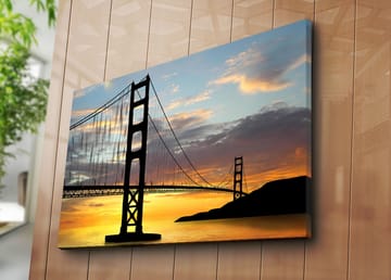 Lerretsbilde 70x100 cm - Silhuett av en bro mot en fargerik solnedgang - Oransje / Svart / Blå - Interiør - Maleri & posters - Lerretsbilder