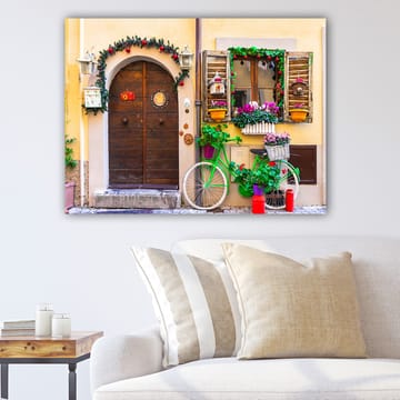 Lerretsbilde 70x100 cm - Sjarmerende dør med blomster og en sykkel i et fargerikt miljø - Grønn / Brun / Rød - Interiør - Maleri & posters - Lerretsbilder