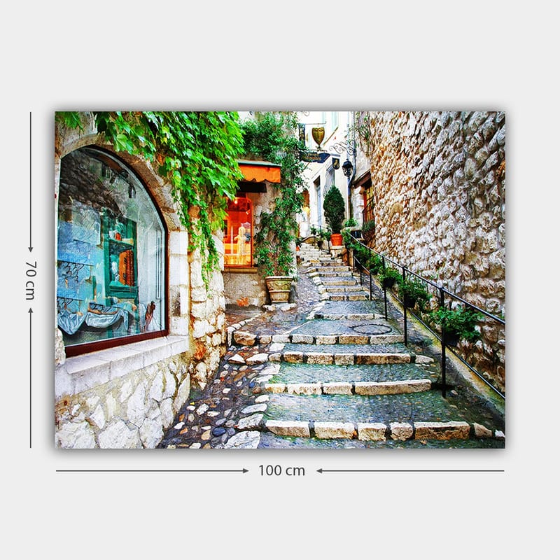 Lerretsbilde 70x100 cm - Sjarmerende smug med steiner og grøntområder som fører oppover, omgitt av historiske bygninger - Grønn / Beige / Oransje - Interiør - Maleri & posters - Lerretsbilder