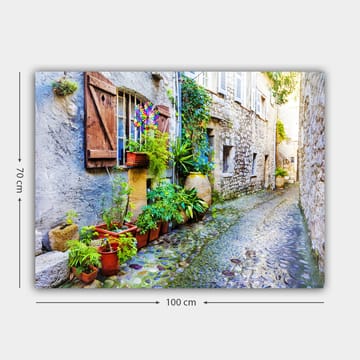 Lerretsbilde 70x100 cm - Sjarmerende smug med steinhus og blomsterpotter som skaper en livlig atmosfære - Grønn / Blå / Beige - Interiør - Maleri & posters - Lerretsbilder