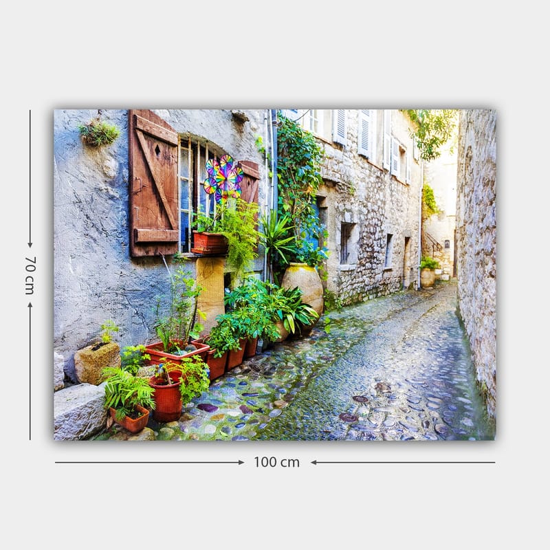 Lerretsbilde 70x100 cm - Sjarmerende smug med steinhus og blomsterpotter som skaper en livlig atmosfære - Grønn / Blå / Beige - Interiør - Maleri & posters - Lerretsbilder