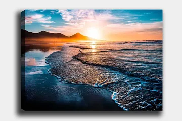 Lerretsbilde 70x100 cm - Solnedgang over en strand med milde bølger som ruller inn mot kysten - Blå / Oransje / Turkis - Interiør - Maleri & posters - Lerretsbilder