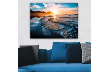 Lerretsbilde 70x100 cm - Solnedgang over en strand med milde bølger som ruller inn mot kysten - Blå / Oransje / Turkis - Interiør - Maleri & posters - Lerretsbilder