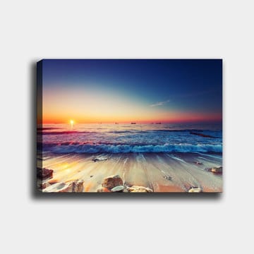 Lerretsbilde 70x100 cm - Solnedgang over havet med myke bølger som ruller inn mot kysten - Blå / Oransje / Rosa - Interiør - Maleri & posters - Lerretsbilder