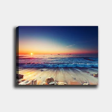 Lerretsbilde 70x100 cm - Solnedgang over havet med myke bølger som ruller inn mot kysten - Blå / Oransje / Rosa - Interiør - Maleri & posters - Lerretsbilder