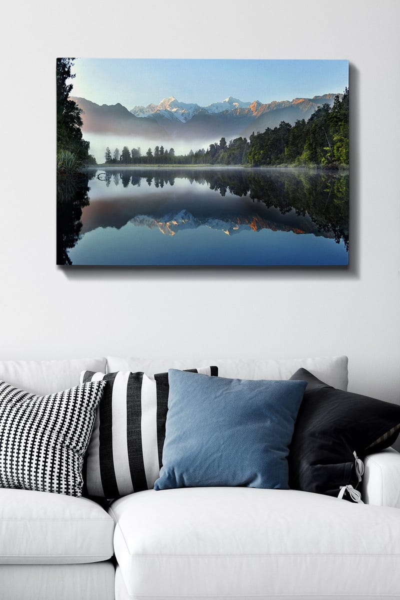 Lerretsbilde 70x100 cm - Speilbilde av majestetiske fjell speilet i en rolig innsjø omgitt av frodig skog - Blå / Grønn / Hvit - Interiør - Maleri & posters - Lerretsbilder
