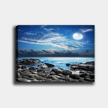 Lerretsbilde 70x100 cm - Stemningsfull naturscene med en måne som skinner over en steinete strand og rolig hav - Blå / Grå / Hvit - Interiør - Maleri & posters - Lerretsbilder