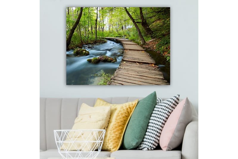 Lerretsbilde 70x100 cm - Stille skogssti som slynger seg over en klukkende bekk omgitt av frodige trær og vegetasjon - Grønn / Brun / Blå - Interiør - Maleri & posters - Lerretsbilder