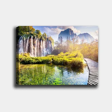 Lerretsbilde 70x100 cm - Storslått fossefall omgitt av frodig vegetasjon og majestetiske fjell - Grønn / Blå / Gul - Interiør - Maleri & posters - Lerretsbilder