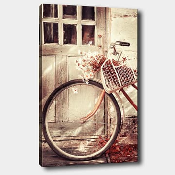 Lerretsbilde 70x100 cm - Sykkel med en kurv fylt med blomster foran en gammel dør - Grå / Brun / Hvit - Interiør - Maleri & posters - Lerretsbilder