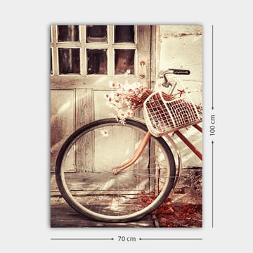 Lerretsbilde 70x100 cm - Sykkel med en kurv fylt med blomster foran en gammel dør - Grå / Brun / Hvit - Interiør - Maleri & posters - Lerretsbilder