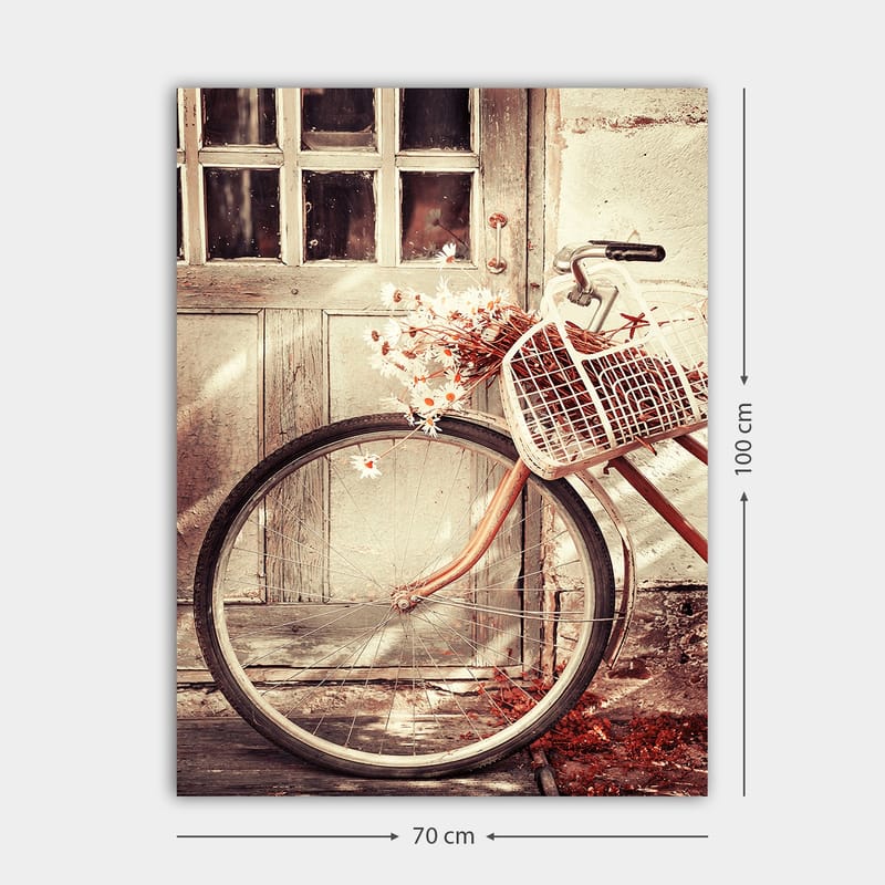 Lerretsbilde 70x100 cm - Sykkel med en kurv fylt med blomster foran en gammel dør - Grå / Brun / Hvit - Interiør - Maleri & posters - Lerretsbilder