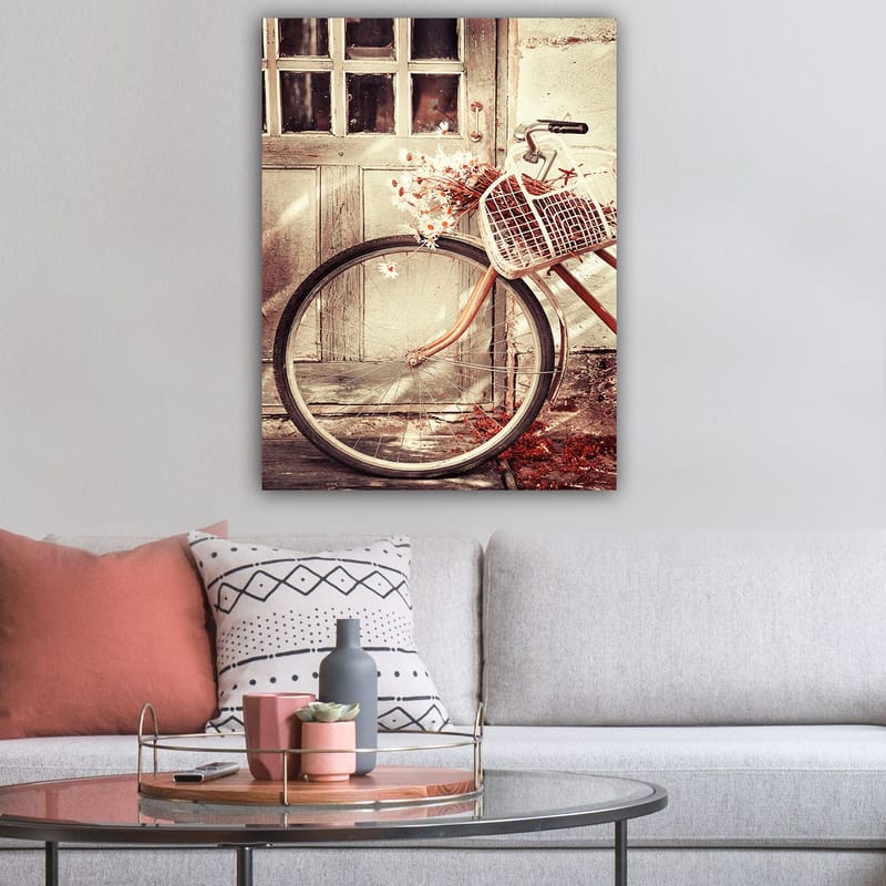 Lerretsbilde 70x100 cm - Sykkel med en kurv fylt med blomster foran en gammel dør - Grå / Brun / Hvit - Interiør - Maleri & posters - Lerretsbilder