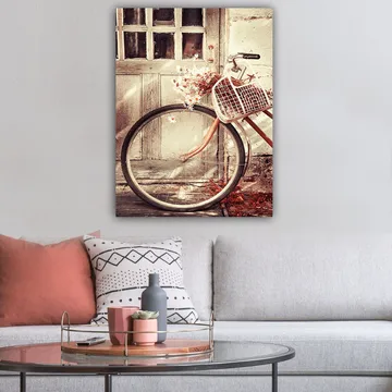Lerretsbilde 70x100 cm - Sykkel med en kurv fylt med blomster foran en gammel dør - Grå / Brun / Hvit - Interiør - Maleri & posters - Lerretsbilder