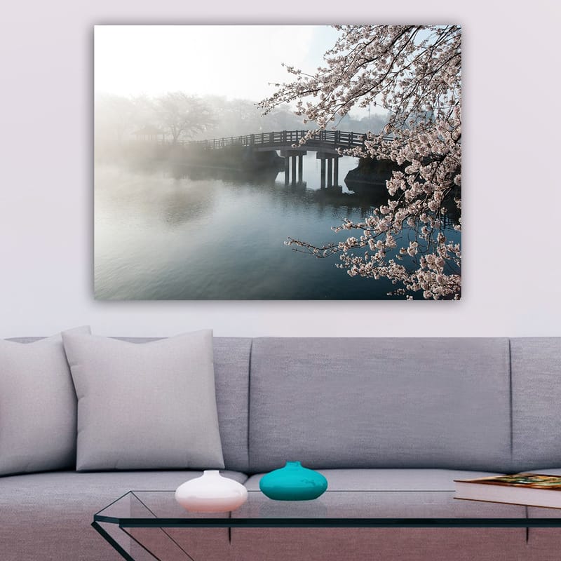 Lerretsbilde 70x100 cm - Tåkete landskap med en bro som går over en stille innsjø, omgitt av blomstrende kirsebærtrær - Lys rosa / Blå / Grå - Interiør - Maleri & posters - Lerretsbilder