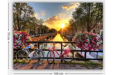Lerretsbilde 70x100 cm - To sykler i pittoresk kanalsetting med blomster og solnedgang - Rosa / Hvit / Grønn - Interiør - Maleri & posters - Lerretsbilder