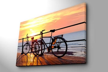 Lerretsbilde 70x100 cm - To sykler som står på en brygge ved solnedgang over havet - Oransje / Svart / Gul - Interiør - Maleri & posters - Lerretsbilder