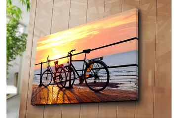 Lerretsbilde 70x100 cm - To sykler som står på en brygge ved solnedgang over havet - Oransje / Svart / Gul - Interiør - Maleri & posters - Lerretsbilder