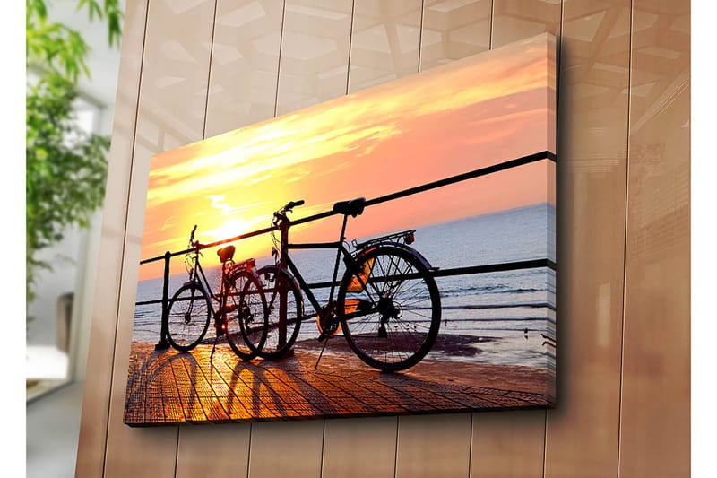 Lerretsbilde 70x100 cm - To sykler som står på en brygge ved solnedgang over havet - Oransje / Svart / Gul - Interiør - Maleri & posters - Lerretsbilder