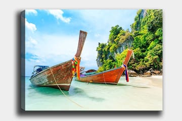 Lerretsbilde 70x100 cm - To tradisjonelle thailandske langbåter på en strand med steiner og frodig vegetasjon i bakgrunnen - Brun / Grønn / Blå - Interiør - Maleri & posters - Lerretsbilder