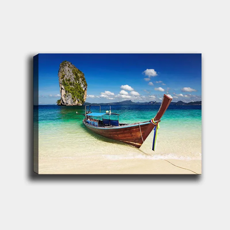 Lerretsbilde 70x100 cm - Tradisjonell båt på en tropisk strand med fjellformasjoner i bakgrunnen, Blå / Grønn / Brun