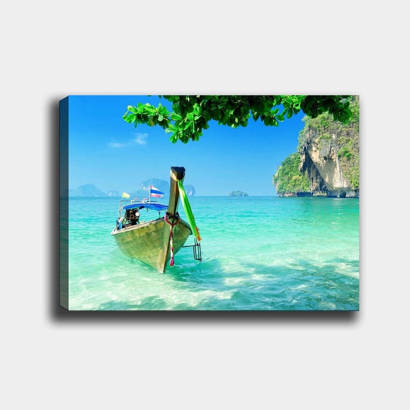 Lerretsbilde 70x100 cm - Tradisjonell båt på en klarblå strand med frodige klipper i bakgrunnen, Turkis / Grønn / Blå