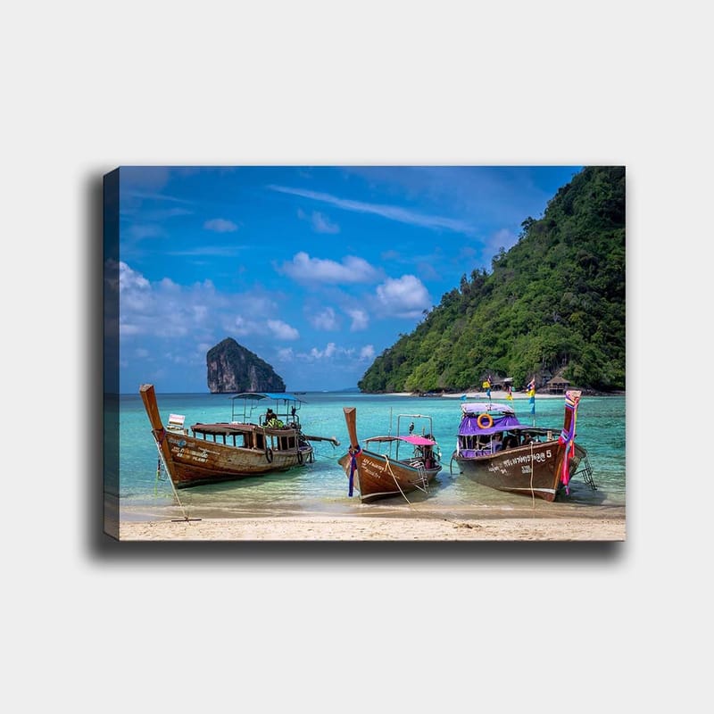 Lerretsbilde 70x100 cm - Tre tradisjonelle langbåter på en strand med en steinete øy i bakgrunnen, Brun / Turkis / Grønn