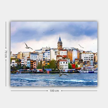 Lerretsbilde 70x100 cm - Utsikt over en by med et historisk klokketårn og fugler som svever over vannet - Blå / Hvit / Beige - Interiør - Maleri & posters - Lerretsbilder