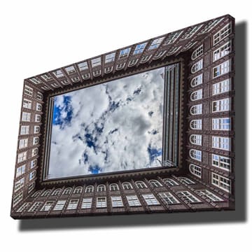 Lerretsbilde 70x100 cm - Utsikt over en bygningsfasade som rammer inn et speilbilde av himmelen - Mørk brun / Hvit / Lys blå - Interiør - Maleri & posters - Lerretsbilder