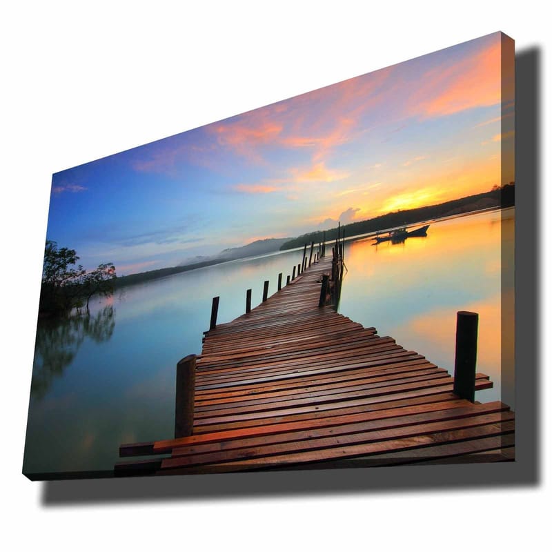 Lerretsbilde 70x100 cm - Vakker brygge som strekker seg ut over en rolig innsjø ved solnedgang, Blå / Oransje / Brun