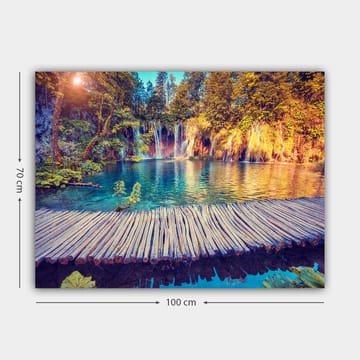 Lerretsbilde 70x100 cm - Vakker foss med klart blått vann omgitt av frodig grøntområde og trær - Blå / Grønn / Brun - Interiør - Maleri & posters - Lerretsbilder