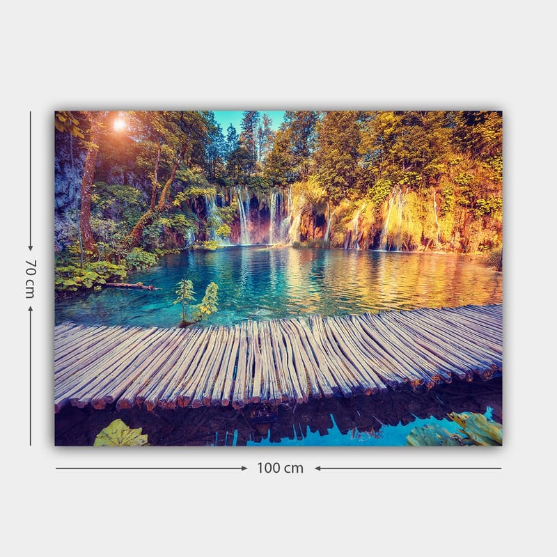 Lerretsbilde 70x100 cm - Vakker foss med klart blått vann omgitt av frodig grøntområde og trær - Blå / Grønn / Brun - Interiør - Maleri & posters - Lerretsbilder