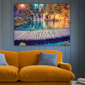 Lerretsbilde 70x100 cm - Vakker foss med klart blått vann omgitt av frodig grøntområde og trær - Blå / Grønn / Brun - Interiør - Maleri & posters - Lerretsbilder