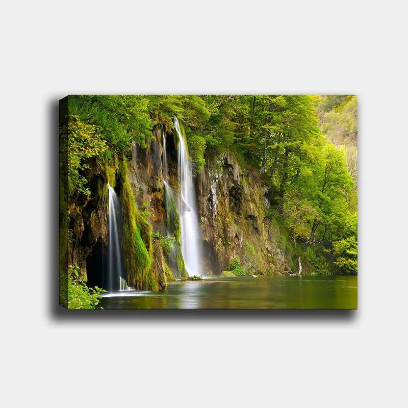 Lerretsbilde 70x100 cm - Vakker foss omgitt av frodig grøntområde, Grønn / Brun / Hvit