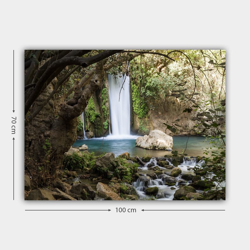 Lerretsbilde 70x100 cm - Vakker foss omgitt av frodig vegetasjon og steiner - Grønn / Blå / Beige - Interiør - Maleri & posters - Lerretsbilder