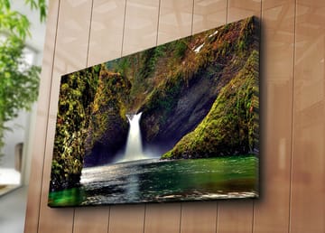Lerretsbilde 70x100 cm - Vakker foss som renner ned mellom grønne klipper i naturskjønne omgivelser - Grønn / Blå / Brun - Interiør - Maleri & posters - Lerretsbilder