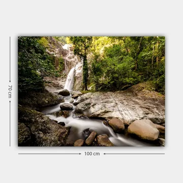 Lerretsbilde 70x100 cm - Vakker fossescene omgitt av frodig grøntområde og steinblokker - Grønn / Grå / Brun - Interiør - Maleri & posters - Lerretsbilder
