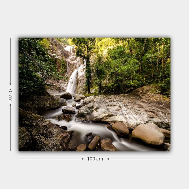 Lerretsbilde 70x100 cm - Vakker fossescene omgitt av frodig grøntområde og steinblokker - Grønn / Grå / Brun - Interiør - Maleri & posters - Lerretsbilder
