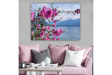 Lerretsbilde 70x100 cm - Vakker gruppe blomster som strekker seg over en innsjø med fjell i bakgrunnen - Rosa / Grønn - Interiør - Maleri & posters - Lerretsbilder
