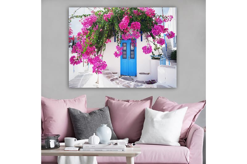 Lerretsbilde 70x100 cm - Vakker hvit bygning med en blå dør omgitt av lilla blomster - Lilla / Blå / Grønn - Interiør - Maleri & posters - Lerretsbilder