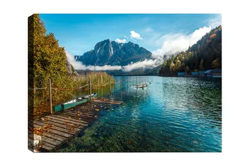 Lerretsbilde 70x100 cm - Vakker innsjø med en brygge, omgitt av majestetiske fjell og høstfargede trær - Blå / Grønn / Gul - Interiør - Maleri & posters - Lerretsbilder
