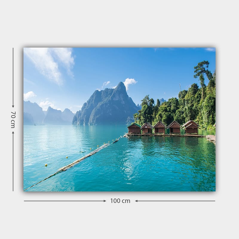 Lerretsbilde 70x100 cm - Vakker innsjø med hytter ved vannet, omgitt av majestetiske fjell og frodig skog - Turkis / Grønn / Brun - Interiør - Maleri & posters - Lerretsbilder