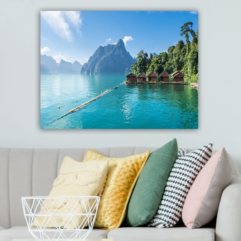 Lerretsbilde 70x100 cm - Vakker innsjø med hytter ved vannet, omgitt av majestetiske fjell og frodig skog - Turkis / Grønn / Brun - Interiør - Maleri & posters - Lerretsbilder