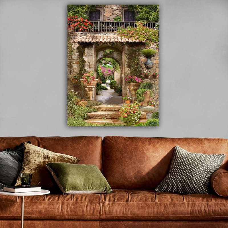 Lerretsbilde 70x100 cm - Vakker og frodig hage med blomsteroppsatser og en steinbue som fører inn til en løvrik gangvei - Grønn / Rosa / Beige - Interiør - Maleri & posters - Lerretsbilder