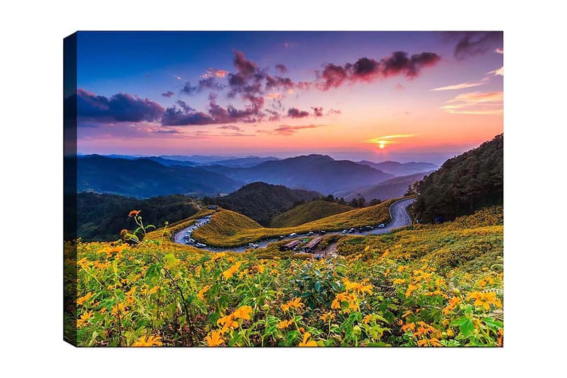 Lerretsbilde 70x100 cm - Vakker solnedgang over en blomstrende dal med svingete veier og fjell i bakgrunnen, Gul / Grønn / Blå