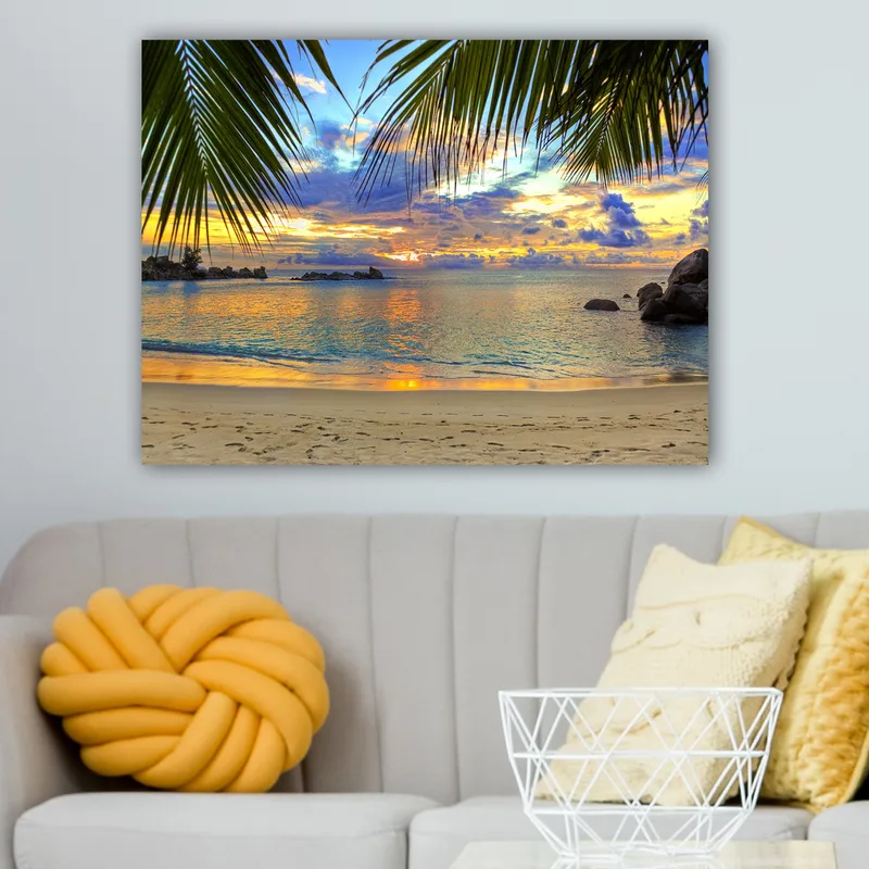 Lerretsbilde 70x100 cm - Vakker solnedgang over en strand med palmer som rammer inn motivet - Blå / Oransje / Grønn - Interiør - Maleri & posters - Lerretsbilder